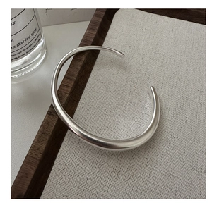 Detail view of a minimalist S925 sterling silver open bangle with a matte satin texture