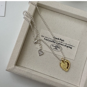 Dettaglio della catena a sfere in argento e ciondolo a cuore d'oro con meet inciso