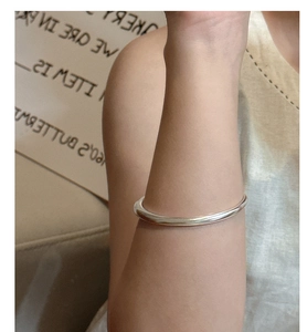 Close-up of minimalist S925 sterling silver matte bangle on model's wrist