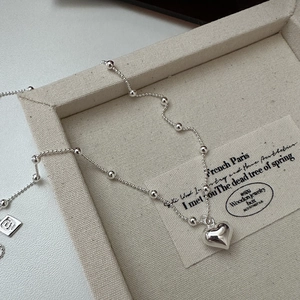 Polished S925 sterling silver heart pendant necklace with delicate bead chain on tray
