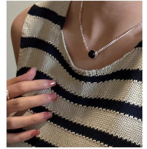 Close-up of minimalist S925 silver necklace with black agate pendant on a model