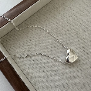Collier avec pendentif cœur en argent sterling S925 minimaliste sur un plateau en bois