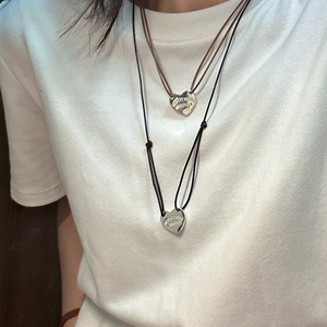 S925 sterling silver heart necklace with adjustable leather cord on a white T-shirt
