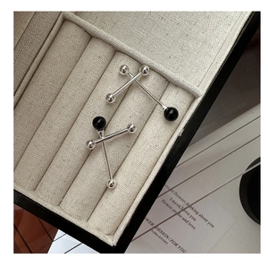 Detailed view of S925 silver balance ball earrings with black onyx beads in a jewelry box