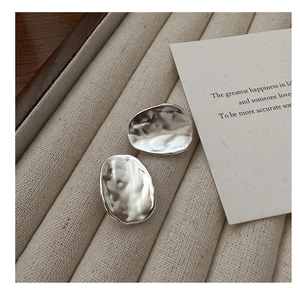 Detailed close-up of S925 sterling silver earrings showing the hammered texture and hallmark