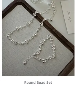 Detailed view of S925 sterling silver beaded necklace and bracelet set on a linen tray