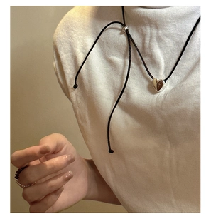 Close-up of S925 silver heart pendant with adjustable black rope on white t-shirt