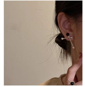 Close-up of S925 sterling silver earrings with black agate beads on a female model