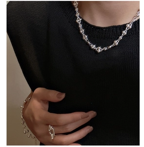 Detail of S925 sterling silver beaded necklace and minimalist ring on black clothing