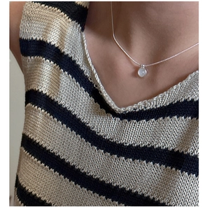 Detail shot of a minimalist S925 silver necklace featuring a round white agate stone pendant