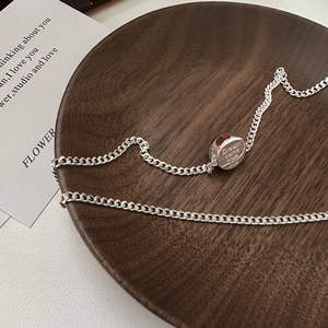 S925 sterling silver necklace with engraved cylindrical pendant on a wooden tray