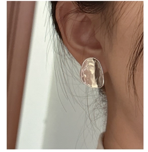 Macro detail of S925 sterling silver irregular stud earrings with hammered texture