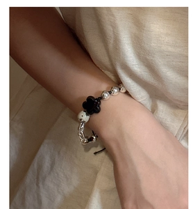 Detailed close-up of S925 silver beaded bracelet with clover charm and dalmatian stone