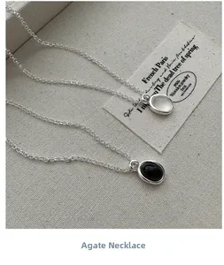 Macro view of minimalist S925 silver necklaces with black and white agate pendants