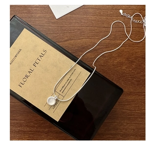Detailed view of S925 sterling silver stamp on white agate minimalist necklace chain