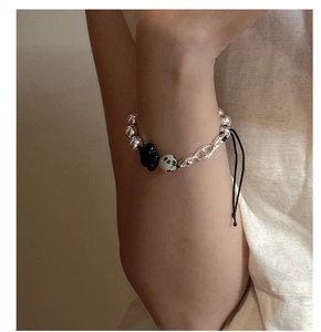 Macro shot of S925 silver beaded bracelet with dalmatian stone and adjustable drawcord