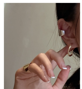 Close-up of minimalist S925 silver ear cuff and rings on model with polished finish
