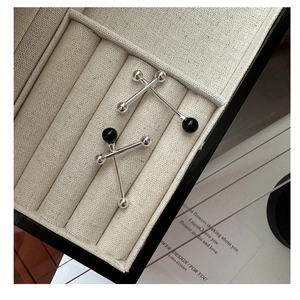 Detailed close-up of S925 silver stud earrings with black onyx and silver beads in a box