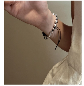 Detail of S925 silver beaded bracelet with natural dalmatian stone and adjustable cord