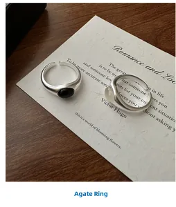 Close-up of minimalist S925 sterling silver rings with matte finish and black agate stone