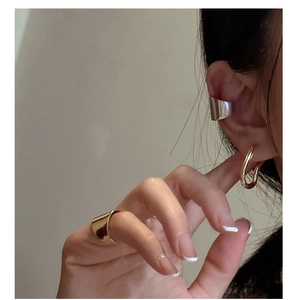 Detail view of stylish S925 sterling silver wavy ear cuffs and minimalist gold ring