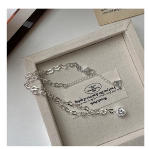 Détails macro des maillons cœur en argent S925 et pendentif en zircon scintillant