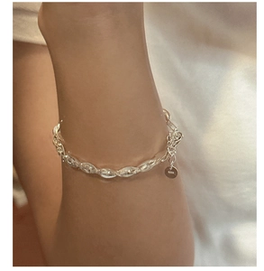 Detail of S925 sterling silver woven chain bracelet with adjustable clasp and logo tag