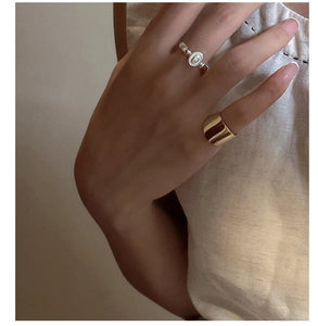 Close-up of stacked vintage silver relief ring and polished wide gold band on a hand