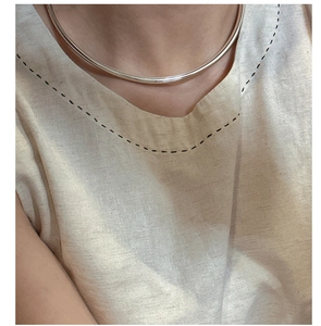 Close-up of a minimalist polished S925 silver collar necklace on a model's neck
