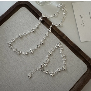 Detailed close-up of S925 sterling silver beaded necklace and bracelet set on a tray