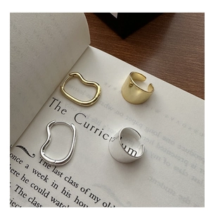 Detail of S925 sterling silver wave earrings and ear cuffs in gold and silver finish