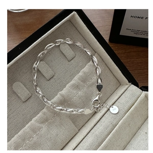 Close-up of S925 sterling silver woven bracelet with lobster clasp and hallmark tag