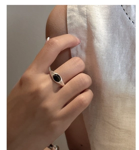 Close-up of minimalist S925 sterling silver ring featuring an oval black gemstone