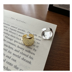 Macro shot of S925 sterling silver stamp on wide wavy texture rings set in gold and silver