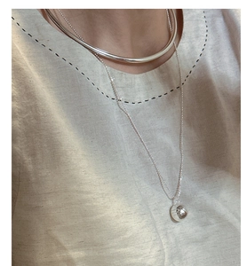Close-up of a minimalist S925 sterling silver hollow choker and beaded ball necklace