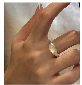 Detail of S925 sterling silver ring featuring a smooth oval yellow gemstone on model hand