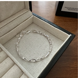 Detail of S925 sterling silver woven bracelet with lobster clasp and round logo tag