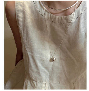 Close-up of minimalist S925 sterling silver hollow collar and round bead pendant necklace