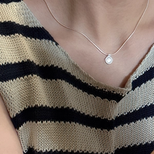 Elegant S925 sterling silver necklace with white agate pendant on a striped knit top