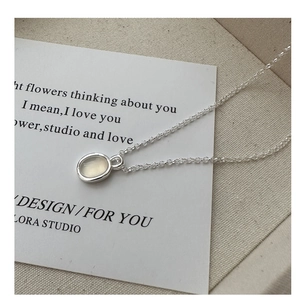 Close-up of S925 sterling silver necklace with oval moonstone pendant on text card