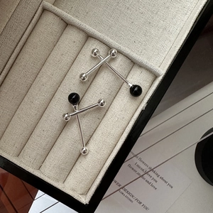 Minimalist S925 silver balance ball earrings with black onyx on beige fabric