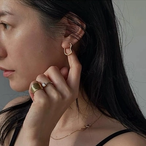 Elegant gold heart-shaped hoop earrings in S925 sterling silver worn by a fashion model