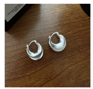 Close-up of S925 sterling silver stamp on matte curved U-shaped silver hoop earrings