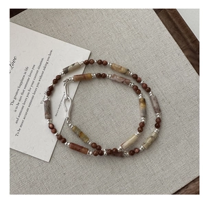 Detail of S925 silver beaded necklace with brown goldstone and marble texture stone beads