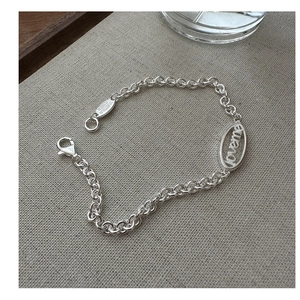 Detail of silver S925 chain bracelet with engraved Love Me and Thanks oval pendants