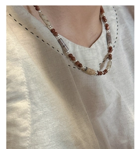 Detail of S925 silver beaded necklace with deep brown stones on linen shirt