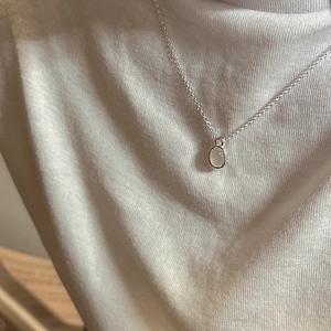Minimalist S925 silver necklace with white agate pendant worn on white knitwear