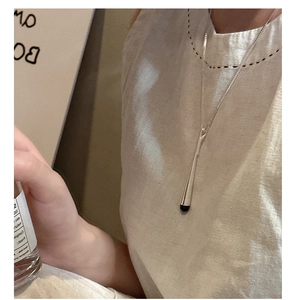 Détail du long collier en argent S925 avec pendentif goutte en émail noir au style épuré