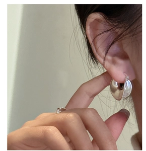 Close-up of matte S925 sterling silver U-shaped hoop earrings worn by a female model