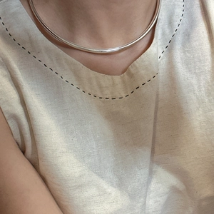 Minimalist S925 sterling silver hollow torque necklace worn by model in natural light